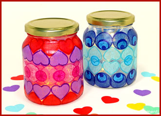 Zwei mit Konfetti beklebte Glas Windlichter