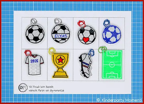 Acht Reflektor Fußball Anhänger mit Vorlage auf Bastelmatte, darunter Fußballbälle, ein Trikot mit '2026', ein Pokal, ein Fußballschuh und ein Fußballfeld, mit bunten Kugelketten