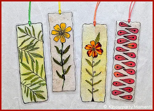 Vier rechteckige Lesezeichen mit handgemalten floralen und geometrischen Mustern, jeweils mit farbigen Bändern zum Herausziehen