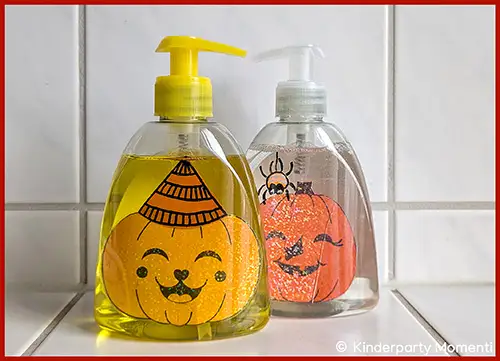 Zwei durchsichtige Seifenspender mit Halloween-Bildern im inneren, einer mit gelber Pumpe und lachendem Kürbisgesicht, der andere mit weißer Pumpe und grinsendem Kürbisgesicht mit Spinne