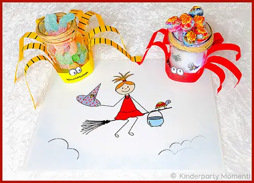 Bunt gestaltetes Tischset mit einer gezeichneten Hexe auf einem Besen und zwei mit Süßigkeiten gefüllten, dekorierten Gläsern mit Papierstreifen als Spinnenbeinen