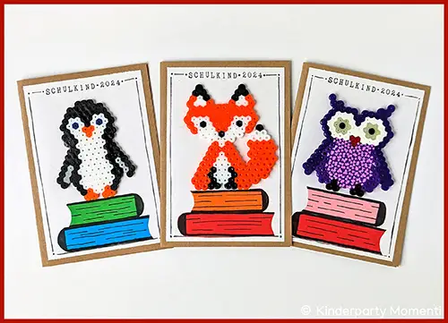 Drei Karten mit Bügelperlen Motiven eines Pinguins, Fuchses und einer Eule jeweils auf einem Stapel bunter Bücher mit dem Text 'SCHULKIND 2024'