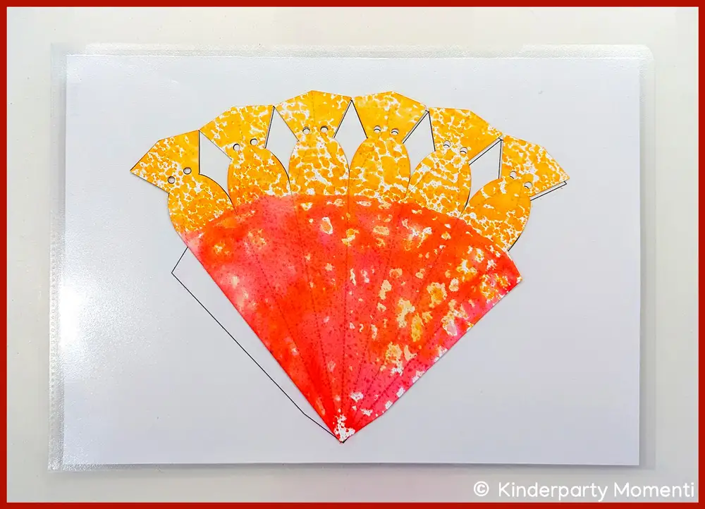 Gefärbt Schultüte trocknen lassen Mit Farben bedruckte kleine Schultüte trocknet auf einem Tablett.