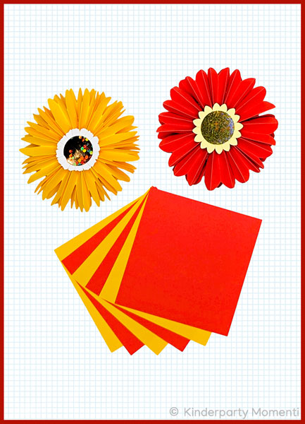 Papierblumen falten aus Notizetteln gelbe und rote Notizzettel und zwei rote und gelbe daraus gefaltete Papierblumen