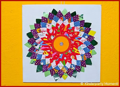 Bunte, symmetrische Blumen-Collage aus verschiedenen gemusterten Papierstücken auf weißem Hintergrund