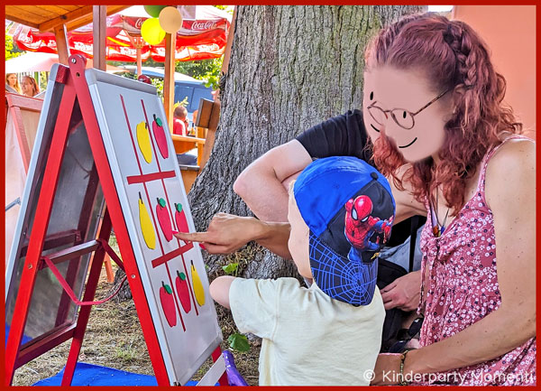 Familie spielt bei einem Fest mit einem großen Tic Tac Toe Spiel