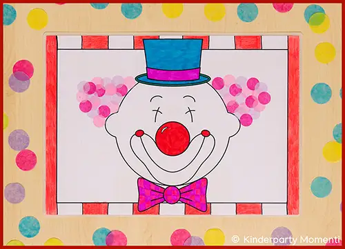 Bunt Tischset mit einem Clownsgesicht, das einen blauen Zylinderhut, eine rote Nase und eine pink-karierte Fliege trägt, umgeben von bunten Punkten auf hellem Hintergrund