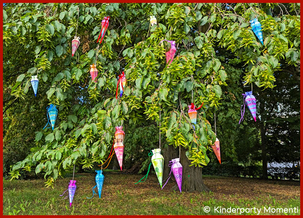 viele kleine bunte Schultüten hängen an einem Baum