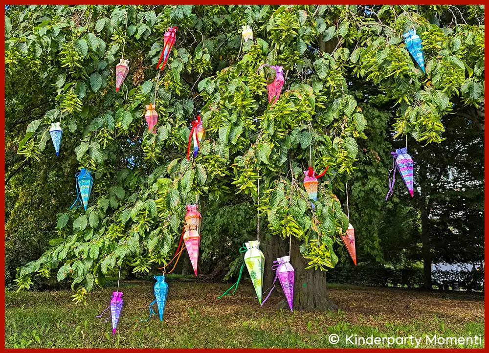 Großer Zuckertütenbaum mit kleinen Schultüten Kleine Schultüten aus Papier hängen in einem Park an einem großen Baum.