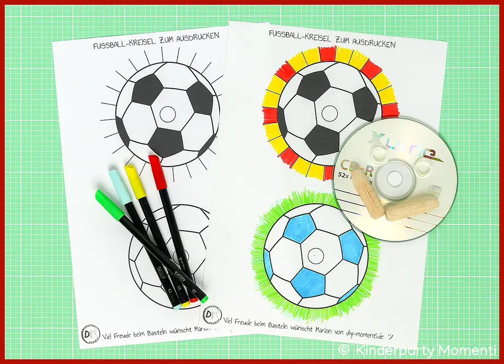 Bastelmaterial & ausdruckbare Vorlagen für Fußball Kreisel basteln mit CDs Vier ausgedruckte Fußball-Kreisel mit unterschiedlichen Farbgestaltungen, daneben vier Filzstifte, Holzdübel und eine CD auf grüner Bastelmatte