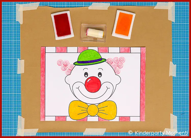 Ausmalbild eines Clownsgesichts mit grünem Hut, roter Nase und gelber Fliege, umgeben von roten Stempelfarben auf braunem Untergrund
