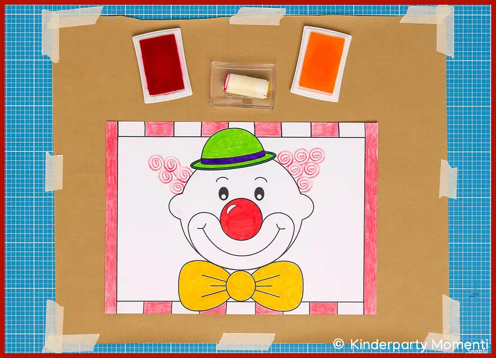 Ausmalbild eines Clownsgesichts mit grünem Hut, roter Nase und gelber Fliege, umgeben von roten Stempelfarben auf braunem Untergrund