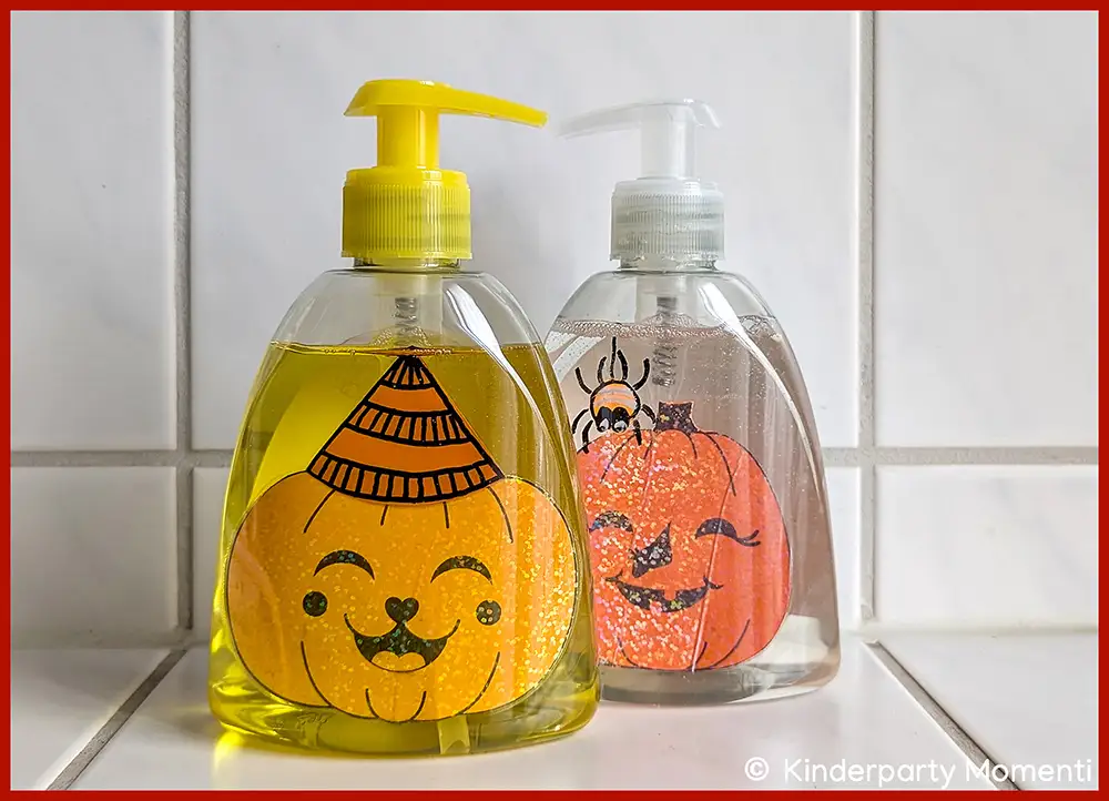 Zwei durchsichtige Seifenspender mit Halloween-Bildern im inneren, einer mit gelber Pumpe und lachendem Kürbisgesicht, der andere mit weißer Pumpe und grinsendem Kürbisgesicht mit Spinne