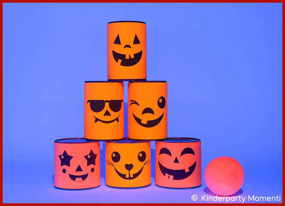 Ideen für Kindergeburtstag im Schwarzlicht - Dosenwerfen selber machen mit Neon Papier DIY Dosenwerfen Spiel aus sechs Dosen mit Kürbisgesichtern auf Neon-Papier, daneben ein im Schwarzlicht leuchtender neonroter Ball.