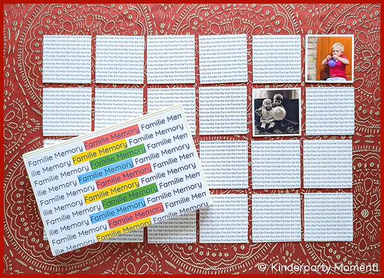 Mehrere Memo-Karten liegen auf einer rot gemusterten Tischdecke, aufgedeckt sind zwei Memo Karten mit Kinderfotos