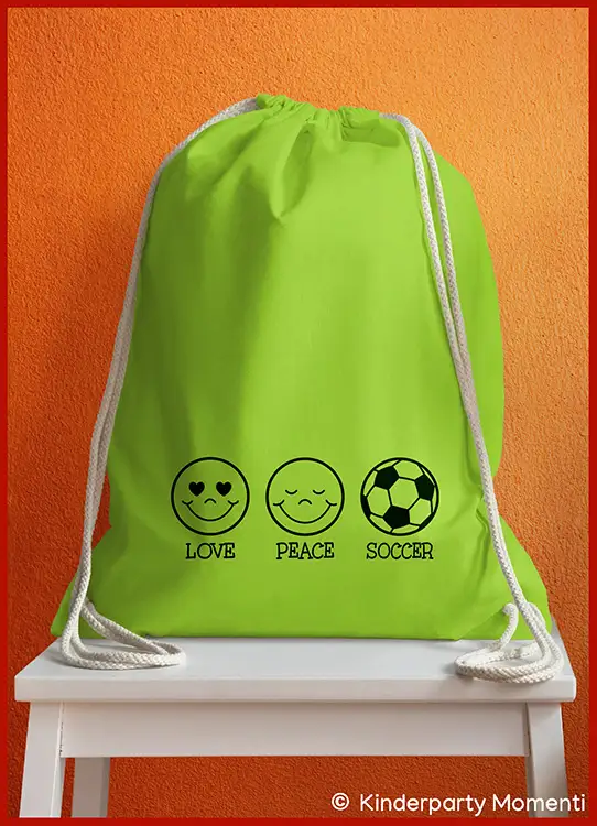 Grüner Turnbeutel mit weißen Kordeln und drei schwarzen Symbolen darunter mit den Worten 'Love Peace Soccer'