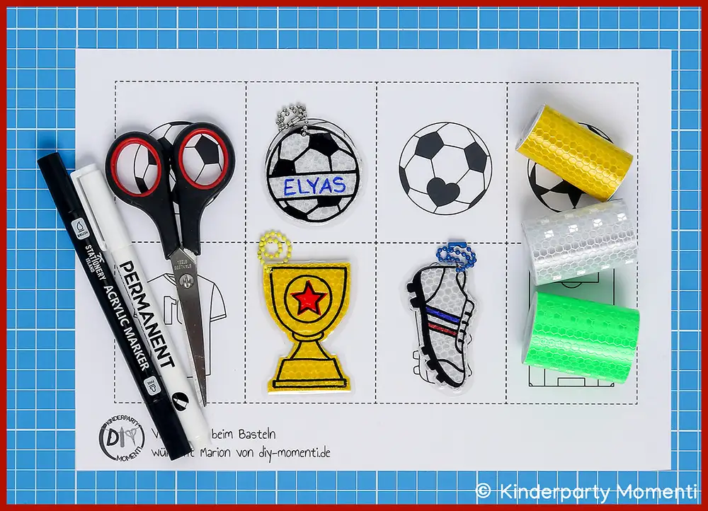 Bastelmaterial & Vorlagen für Fußball Anhänger aus Reflektorband Bastelvorlage mit Fußballmotiven, Schere, schwarzer Permanentmarker und bunte Reflektierende Klebebänder auf blauer Schneidematte