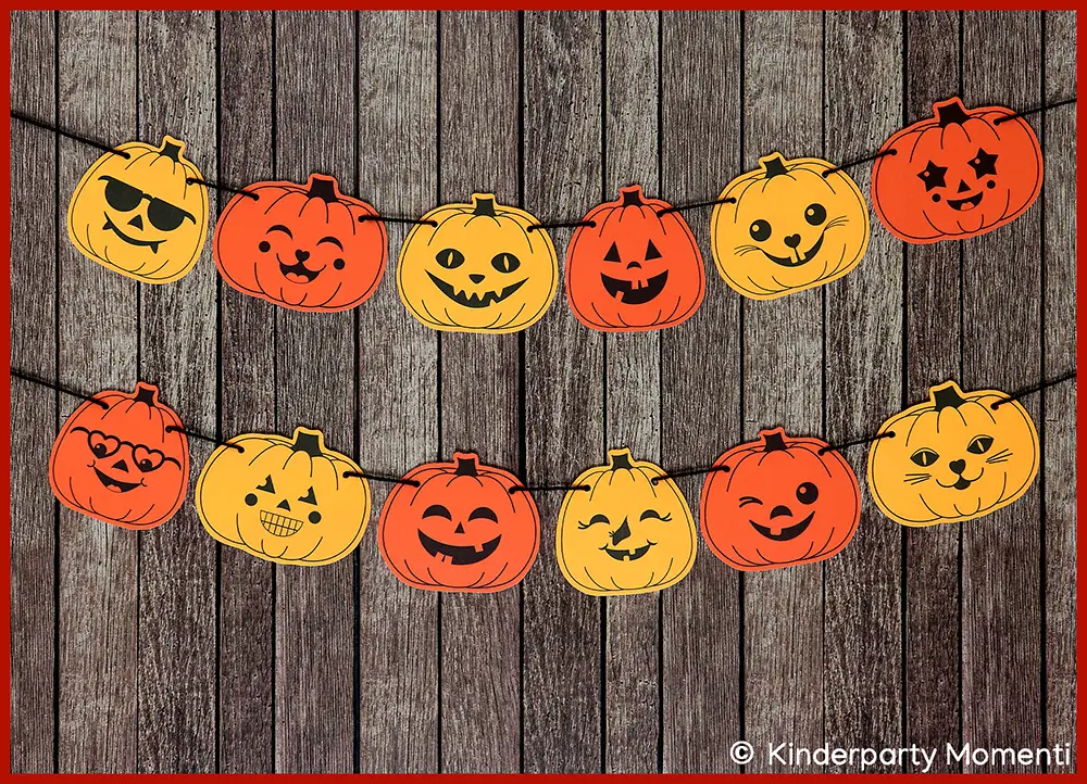 kleine freundliche Kürbisgesichter als Halloween Girlande An einer Holzwand hängen in zwei Reihen untereinander kleine Kürbisse aus Papier.
