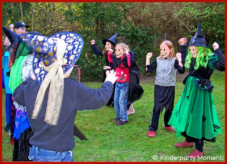 'Stein-Schere-Papier' Spielvarainte für Hexengeburtstag Kinder mit Verkleidung als Hexen und Zauberer spielen auf einer Wiese im Garten