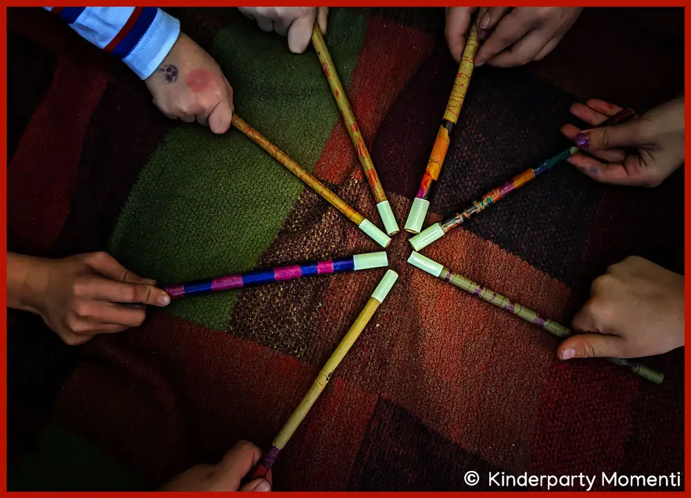 Hexen Zauberstäbe basteln mit Kindern beim Kindergeburtstag Kinderhände halten ihre selber gebastelten Zauberstäbe sternförmig in die Mitte