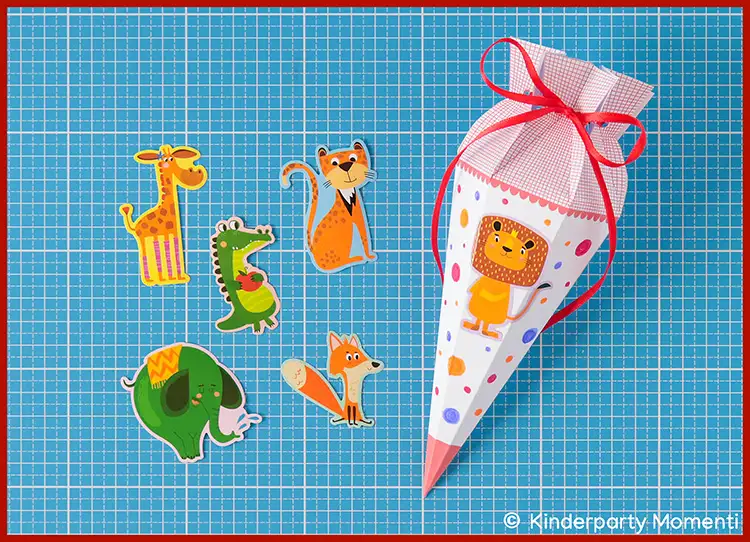 Kleine Schultüten selber basteln und mit Stickern verzieren Schultüte mit Löwenmotiv und roten Schleifenbändern neben Tierstickern auf blauer Bastelmatte