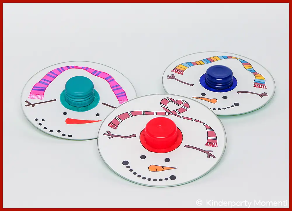 DIY Schneemann Kreisel Spiele aus alten CDs selber basteln Drei CDs mit aufgemalten Schneemann-Gesichtern und bunten Hüten als Bastelidee