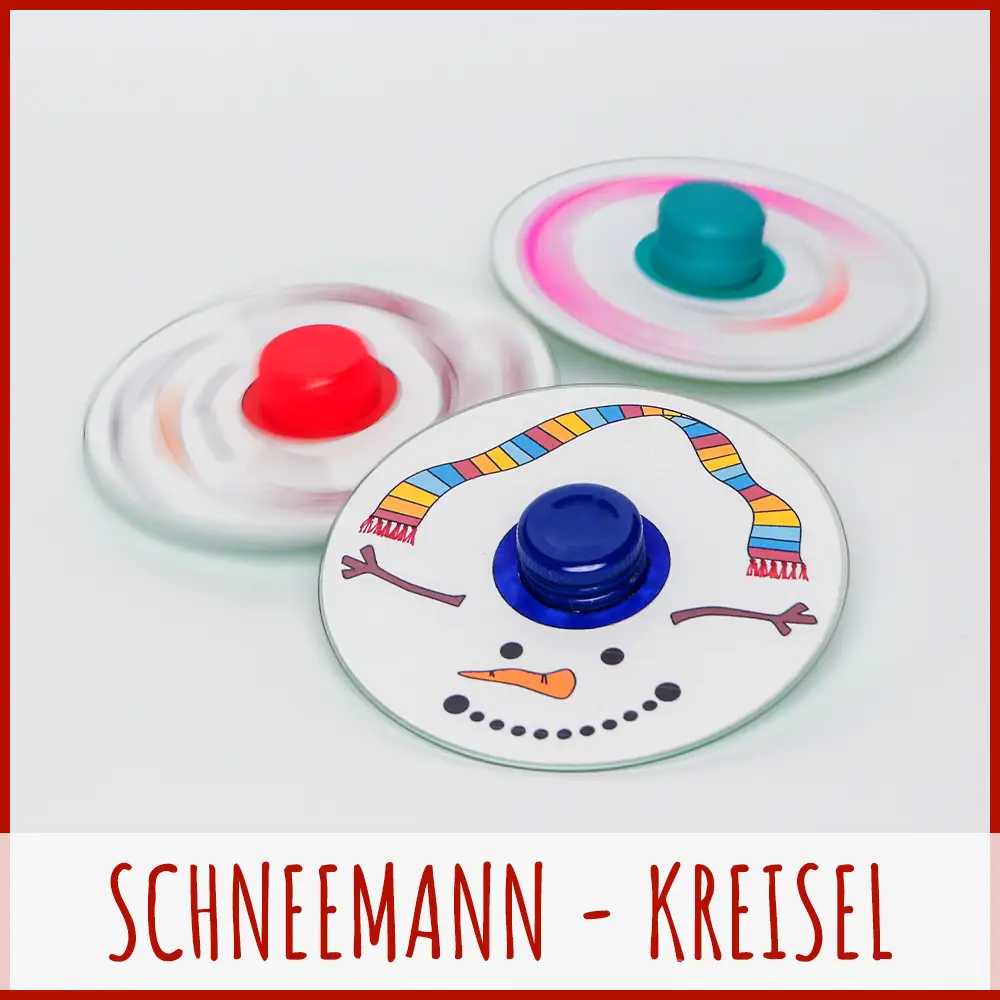Selbstgebasteltes Kreisel Spielzeug für den Winter Drei mit Schneemann-Gesichtern und bunten Schals bemalte, selbstgebastelte Kreisel aus CDs mit bunten Drehknöpfen