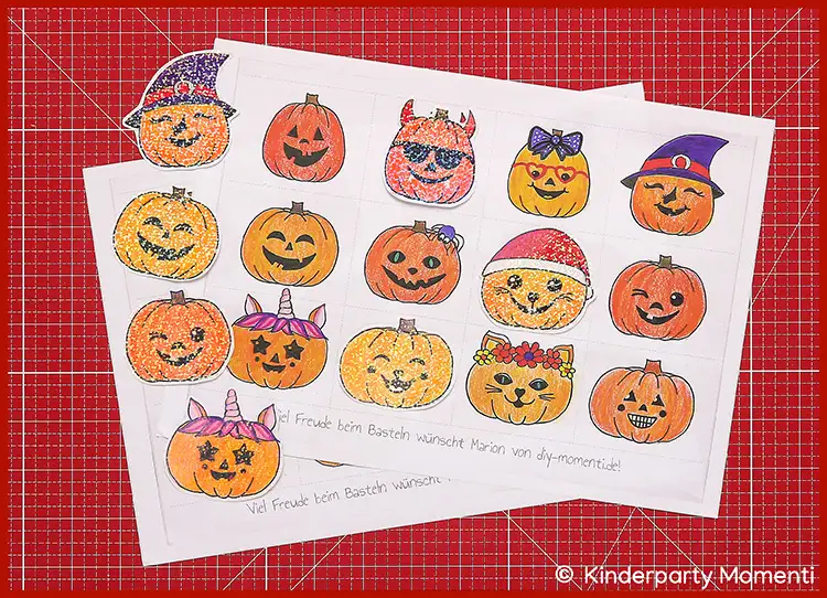 Zwei ausgedruckte Bastelvorlagen mit bunt ausgemalten Kürbisgesichtern in verschiedenen Halloween-Motiven auf roter Schneidematte
