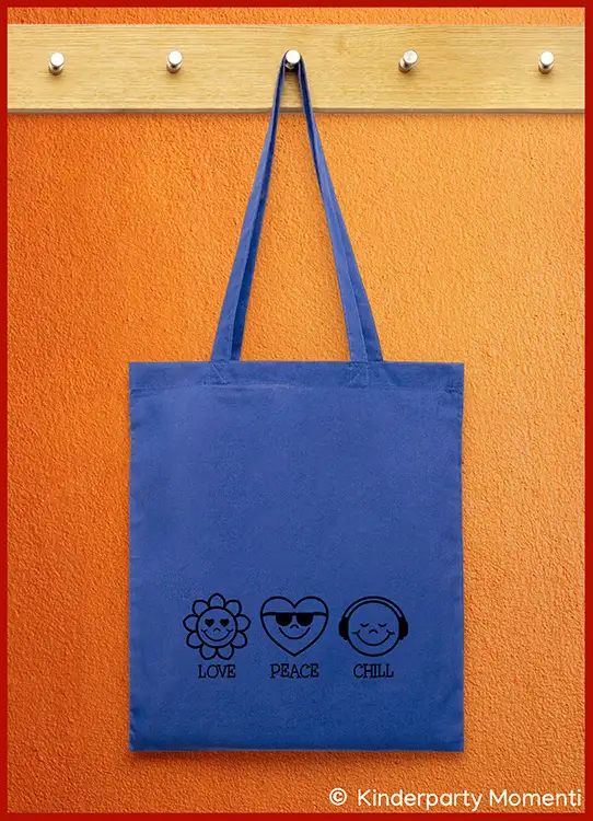 Blaue Jutetasche mit schwarzen Symbolen einer Blume, eines Herzens mit Sonnenbrille und eines lächelnden Gesichts mit Kopfhörern sowie den Worten 'Love Peace Chill'