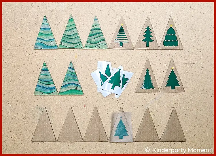 Dreieckige Memo-Karten mit verschiedenen Tannenbaum-Motiven in Grün- und Blautönen auf hellem Untergrund