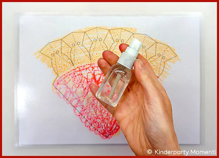 Hand hält eine kleine transparente Sprühflasche, im Hintergrund Schultüten Malvorlage