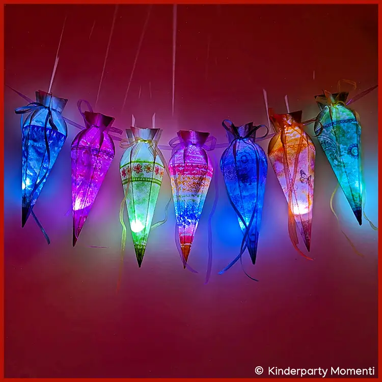 Bunte Mini-Schultüten-Lichterkette mit sieben leuchtenden Schultüten aus Papier und Schleifenbändern