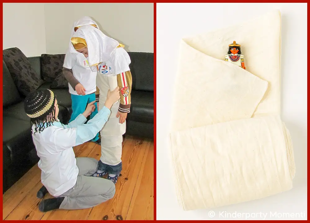 Kindergeburtstag Spiele für ägyptische Party - Mumienwickeln ohne Klopapier Bild 1: Drei Kinder mit ägyptischen Kostümen spielen beim Kindergeburtstag Mumienwickeln mit einer langen, schmalen Stoffrolle. Bild 2: Kleine ägyptische Spielfigur liegt in einer langen, schmalen Stoffrolle