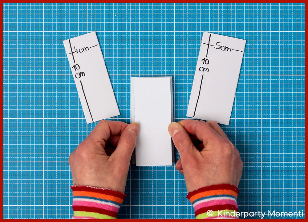 Hände kleben Moosgummi für Stempel zusammen daneben passende Moosgummi Streifen, beschriftet mit '4cm 10cm' und '5cm 10cm'