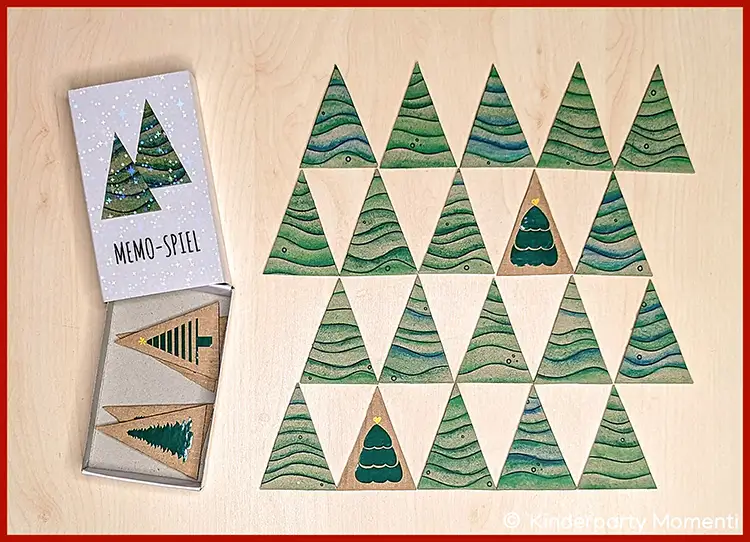 Dreieckige Memo Spielkarten mit verschiedenen Tannenbaum-Motiven und eine Streichholzschachtel mit aufgeklebten Tannenbäumen