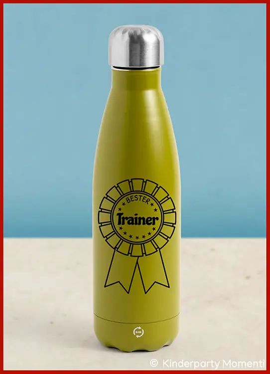 Grüne Trinkflasche mit silbernem Schraubverschluss und schwarzem Aufdruck einer Medaille mit dem Schriftzug 'Bester Trainer'