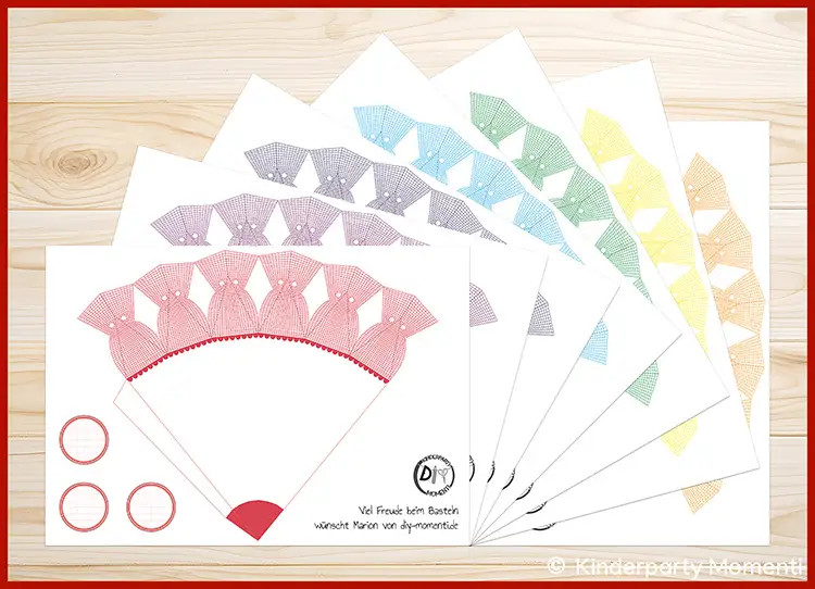 Sieben Druckvorlagen (PDF) für kleine Schultüten in Regenbogen Farben Auf einem Tisch liegen sieben Vorlagen (A4) für kleine Schultüten zum Ausdrucken in Regenbogenfarben.