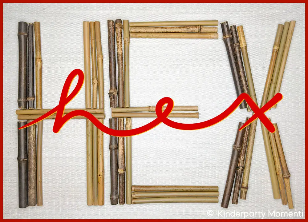 Bambus Holz zum Zauberstab basteln Bambusstäbe in verschiedenen Brauntönen bilden die Buchstaben H, E, X, darüber roter  geschwungener Schriftzug 'hex'.